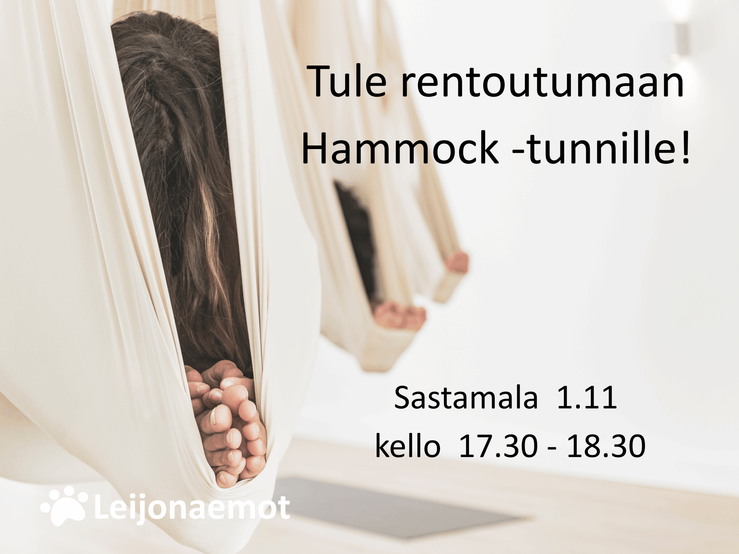 Kaksi valkoista ilmajoogakangasta, hammockia, roikkuu katosta. Alla näkyy harmaa joogamatto.